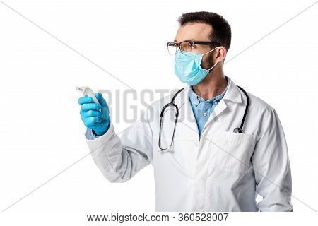 Doctor In Medical Mask And White Coat Holding Non-contact Pyrometer Isolated On White