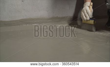 Workers Cover The Concrete Screed With Mortar And Make Waterproofing. The Process Of Waterproofing T