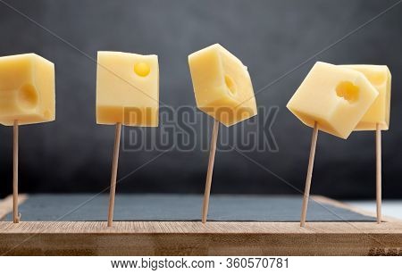Portions (cubes, Dice) Of Emmental Swiss Cheese Punctured In Toothpicks.