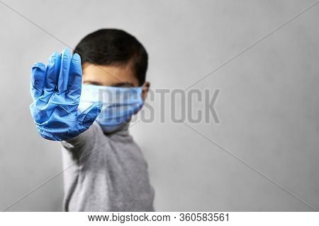 7 Years Old Middle-eastern Boy In Medical Face Mask And Protective Gloves Shows Hand Gesture - Stop.