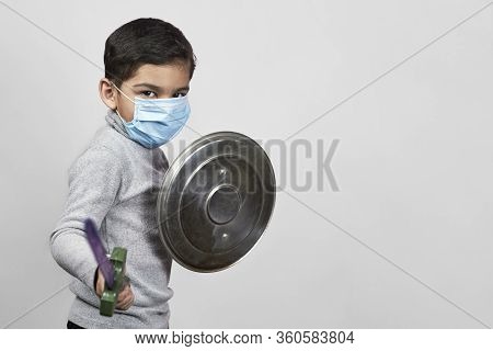 Bored Boy In Medical Face Mask Plays Knight Cavalier. Little Moddle-eastern Kid In Surgical Masks Ha