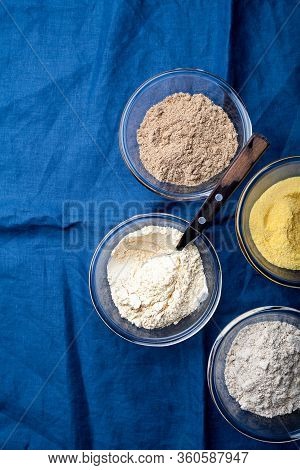 Various Vegetable Gluten Free Flour Corn,sesame,oat,coconut In Glass Bowl On Blue Textile Background