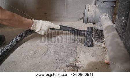 Worker Vacuuming Concrete Floors. Preparing The Floor For Waterproofing. Construction Cleaning With 