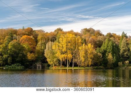 View Of The Autumn Colours Around The Lake At Stourhead Gardens In Wiltshire.