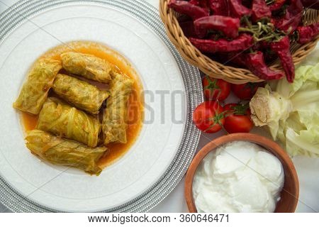 Meat Stuffed Cabbage Leaves, Stewed In Tomato Sauce . Cabbage Stuffing On A White Plate . Red Pepper