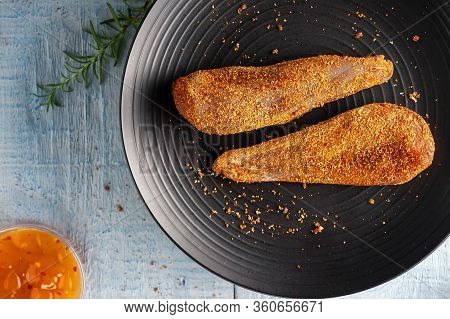 Seasoned Chicken With Hot Sauce And A Sprig Of Rosemary