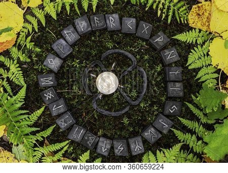 A Circle Of 24 Scandinavian Runes On The Background Of Moss And Leaves In The Autumn Forest. In The 