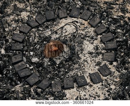 Circle Of 24 Norse Runes Stones With Viking Amulet Inside On Ashes Background.