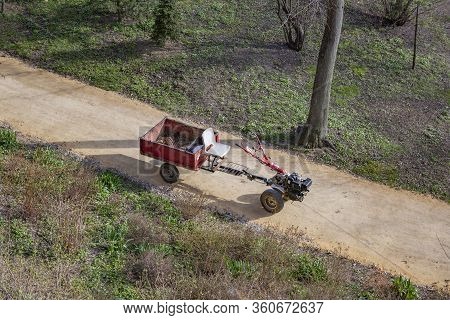 Old Walk-behind Tractor With A Trailer In The Park