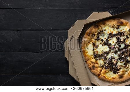 Pizza Funghi In An Open Delivery Box, Dark Backdrop. Delivery Foods, Takeaway Food Concept: Pile Of 