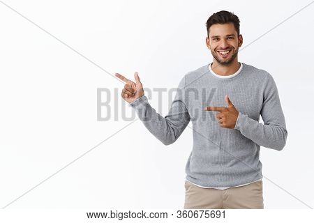 Good-looking Charming Bearded Caucasian Guy With Short Stylish Hairstyle, Wear Grey Sweater, Pointin