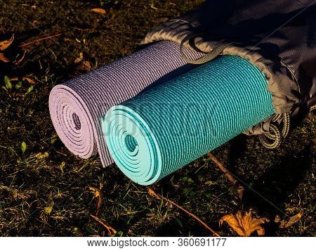 Yoga Mats In Grey Cover On Grass. The Concept Of A Healthy Lifestyle. Yoga Or Physical Education Cla