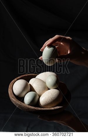 Araucana Eggs And Goose Eggs On A Wooden Plate