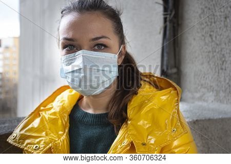Young Beautiful Girl Yellow Jacket Green Eyes Long Hair Poses In Medical Protective Face Mask Agains