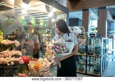 Dark-haired Asian Flower Shop Assistant Workling In A Shop
