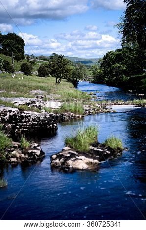 Rural Scene Of The River Wharfe Meandering Along The Dale Towards The Village Of Kettlewell