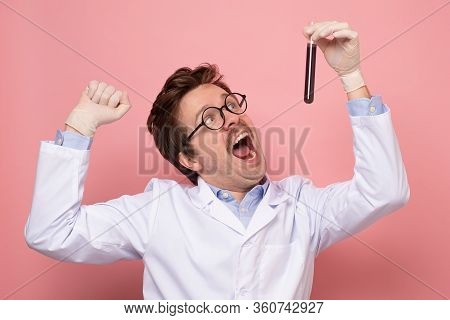 Scientist Hlding A Glass Tube With Blue Fluid Being Happy He Made A Great Discover.