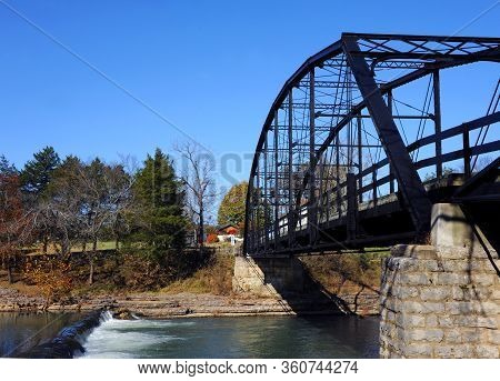 Historic War Eagle Mills Bridge Spans The War Eagle River In Northern Arkansas.  Small Waterfall Tri