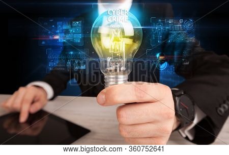Businessman holding lightbulb with CYBER CRIME inscription, online security idea concept