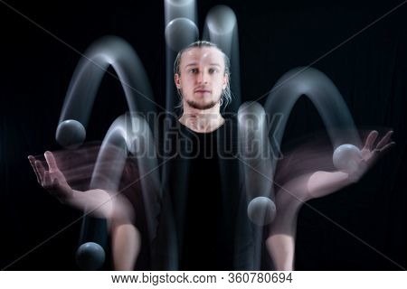 Abstract Image Of Juggler With Smoothed White Balls In Motion
