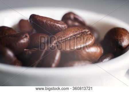 Coffee beans and a white Cup on the kitchen table
