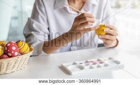 Happy Asian Woman Painting Eggs For Eastertime At Home. Family Preparing For Easter.