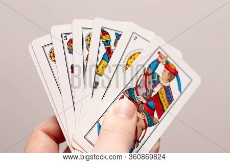 Split,croatia April 2020
A Hand Holding Several Italian Old Playing Cards. Popular Game In The Medit