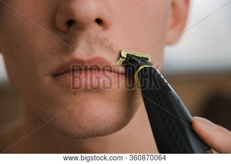 Young Man Shaves Off His Mustache With A Trimmer