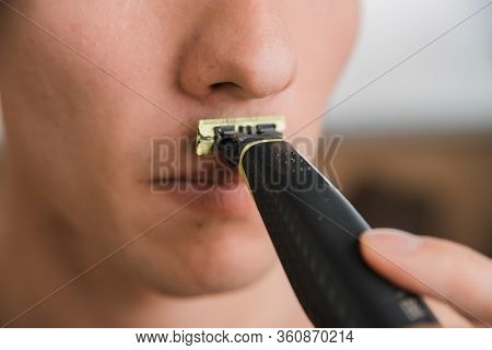 Young Man Shaves Off His Mustache With A Trimmer