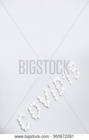 Covid-19 Inscription Made Of Round White Tablets On A White Background, Medical Concept On The Theme