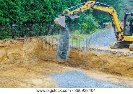 Working On A Construction Excavator Moving Gravel Stones For Foundation A New Home