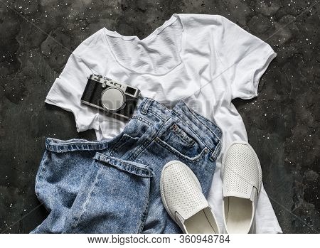 Simple Women's Look - White T-shirt, Mom's Jeans, White Sneakers And A Vintage Camera On A Dark Back
