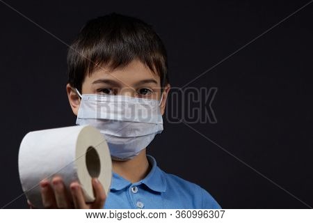 A Child In A Protective Mask Holding Toilet Paper Napkins