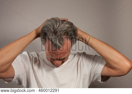 Mature Man 60plus Doing Back Of The Neck Stretches For Back And Neck Pain Relief