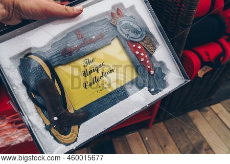 Calgary, Alberta, Canada - July 16, 2022: Hand Holds Up A Picture Frame With The Calgary Stampede Lo