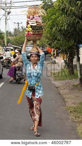 Bali, Indonesië - Jul 8: Een vrouw draagt een mand van Fruit aan de tempel op de 8e 2011 juli tijdens T