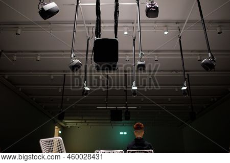 Young Man Listening To Sound Music Surround Installation With Many Speakers Above