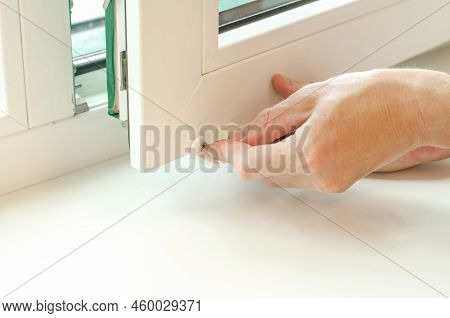 Close-up Of Male Hands Installing Roller Blinds On The Window. Installation Of Roller Blinds