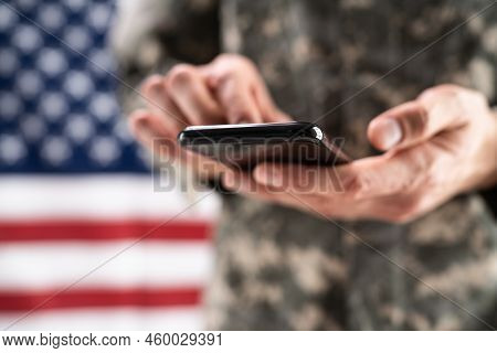 Soldier Holding Mobile Phone. Military War Espionage