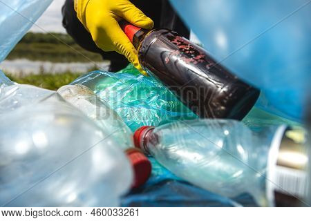 Close-up Of A Hand Throwing Garbage Into A Plastic Bag. View From Inside The Bag. The Concept Of Car