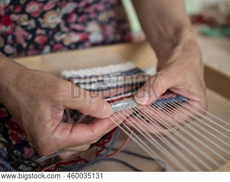 Artisan Weaver Is At Work On The Hand Loom. Tapestry Weaving, Selective Focus. Work Process Of Artis