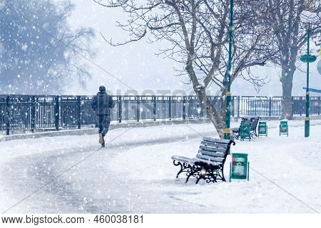 A Man Takes A Morning Jog In A Park In The City Of Khmelnytskyi, Ukraine, During A Snowfall