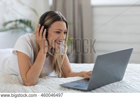 Relaxed Young Lady Watching Movie Online, Using Computer