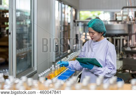 Woman Worker Using Checking Quality Or Checking Stock Of Products In Beverage Factory. Worker Qc Wor