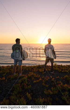 Surfers Watching The Waves At Sunset
