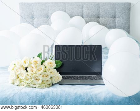 Bouquet Of White Blooming Roses With Laptop On The Bed. White Flowers With Lying On Blue Bed With Co