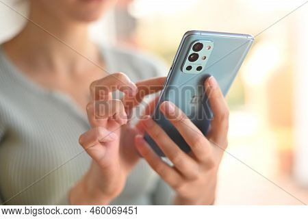 Poland, Poznan - 29 March, 2022. Close-up Woman Uses Modern Phone Oneplus 9r Flipping Through News F