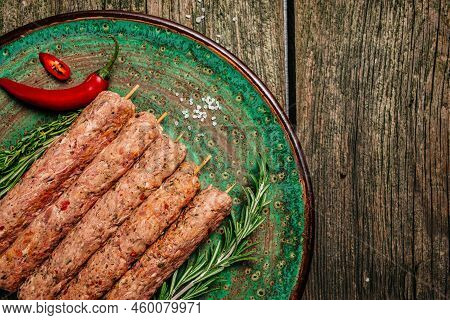 Raw Lula Kebab On Skewers With Spices Dark Background. Lula Kebab, Traditional Caucasian Dish,