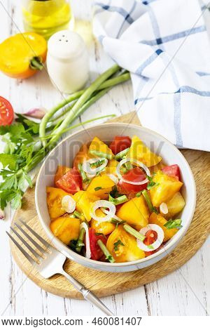 The Concept Of Vegan Or Diet Food. Tomato Salad Made From A Mix Of Red And Yellow Tomatoes And Green