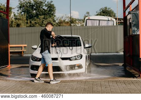 Man Is Wiping The Car With A Microfiber Cloth. Contactless Self-service Car Wash. Personal Car Care 